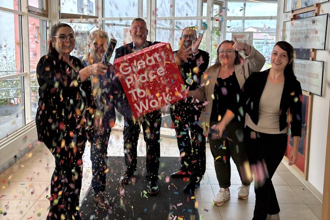 Wir sind ein Great Place to Work Mitarbeiter feiern mit Konfetti die Zertifizierung Great Place to Work